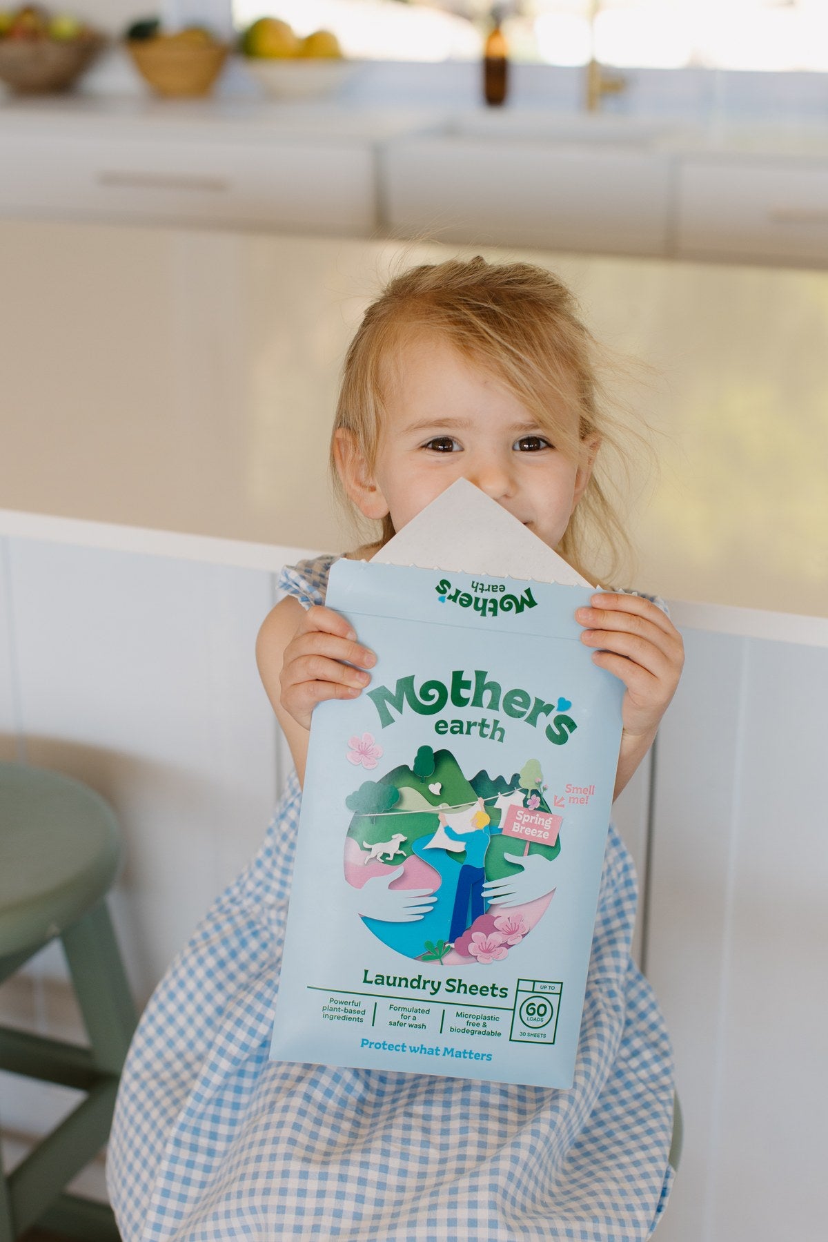 Child holding a Mother's Earth laundry sheet